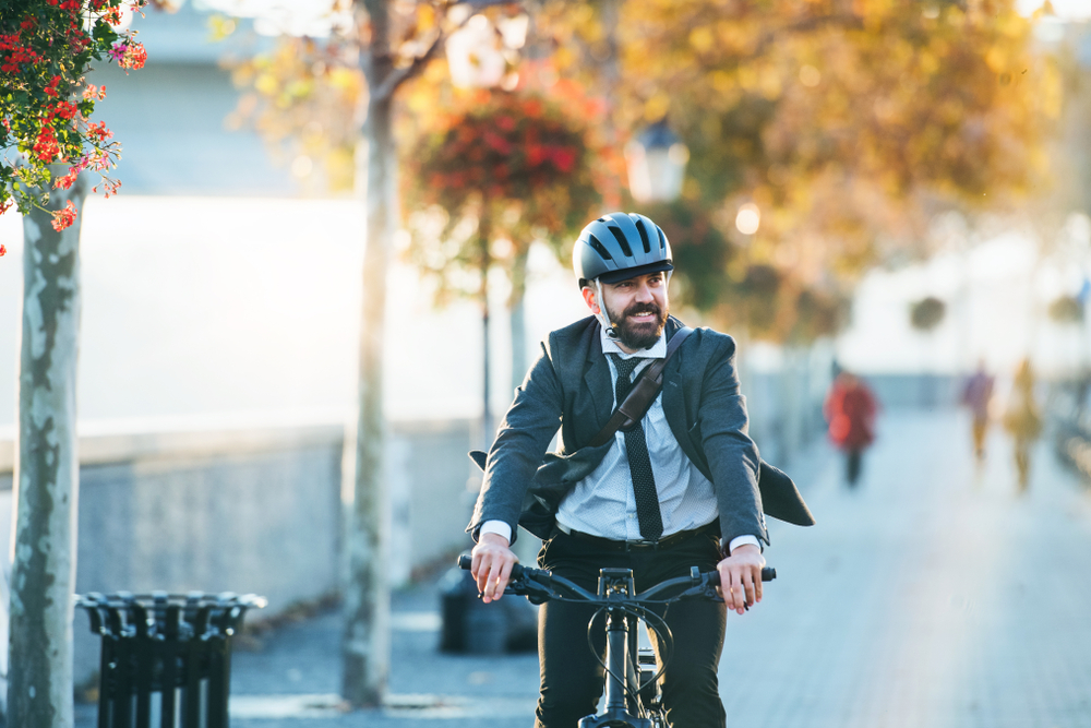 Business man biking to work in a suit