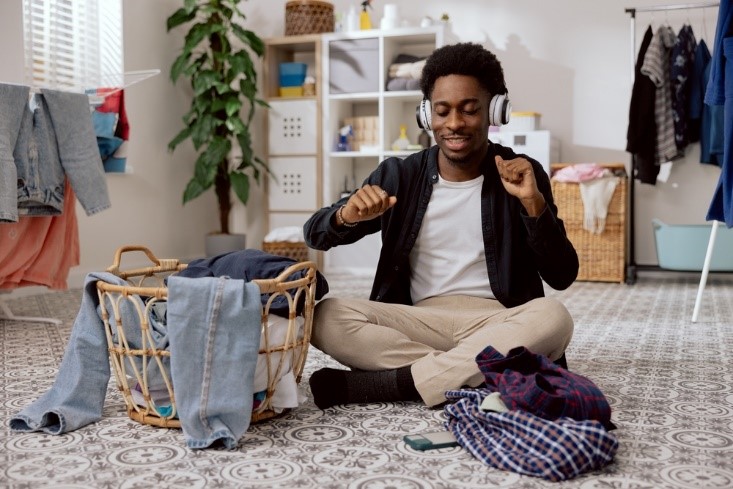 happy young african american man listening to music while sitting down and vibing