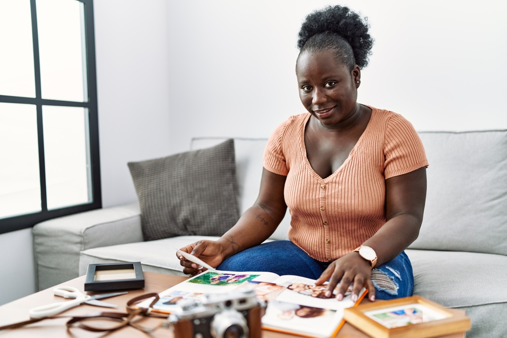 Young African American woman looking through photobook