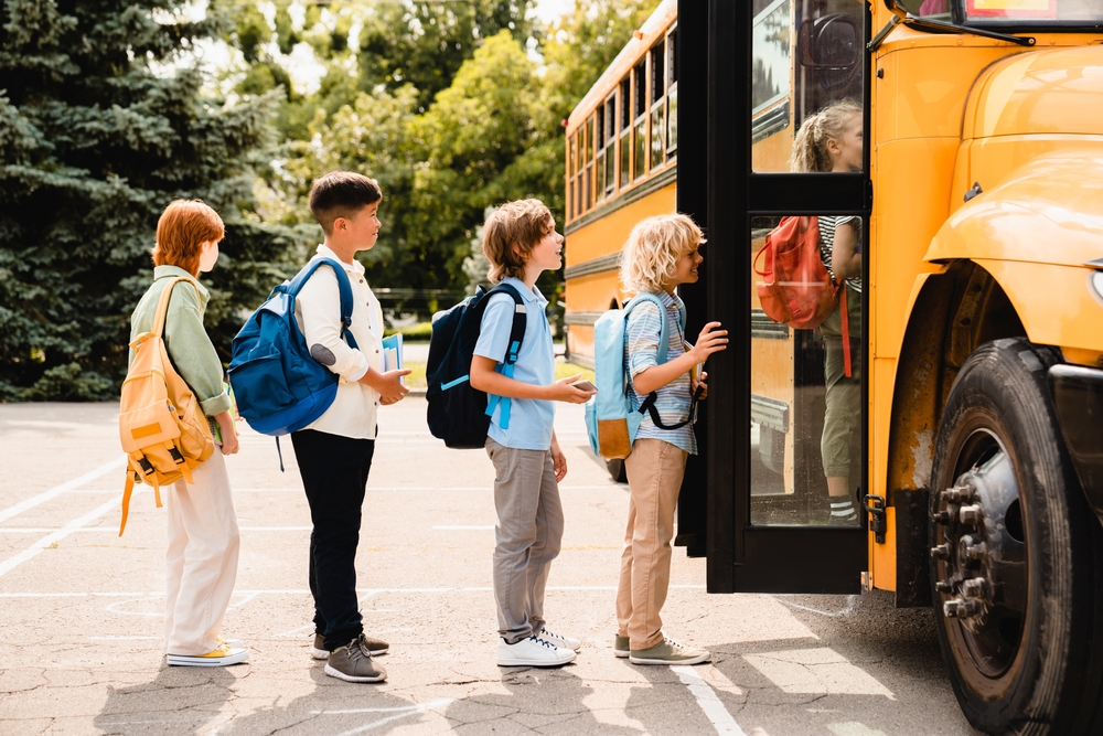 Kids in line to get on a school bus