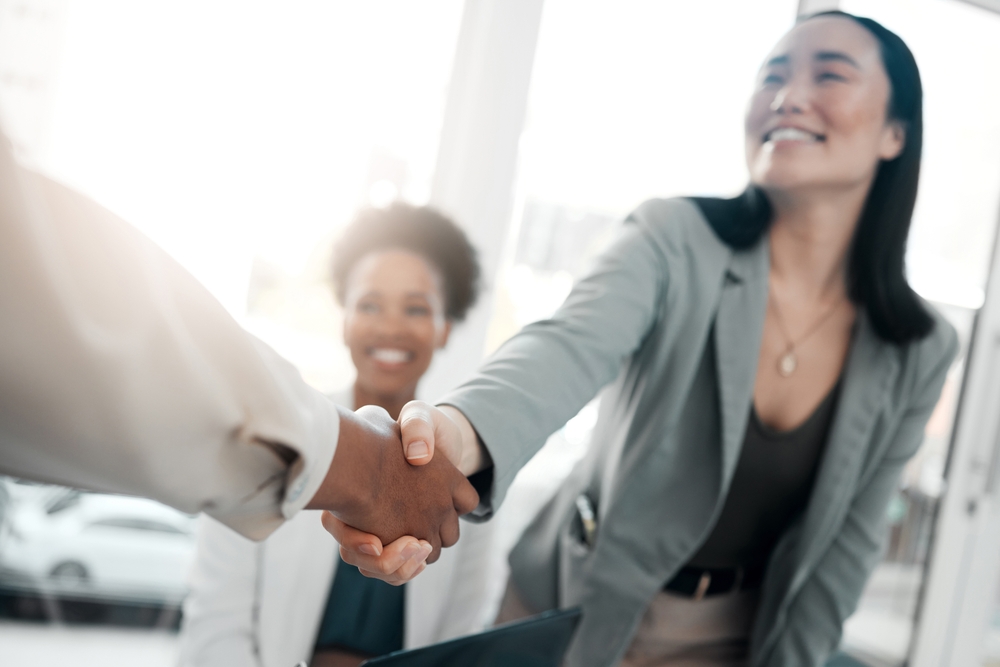 Woman shaking another person's hand after an interview