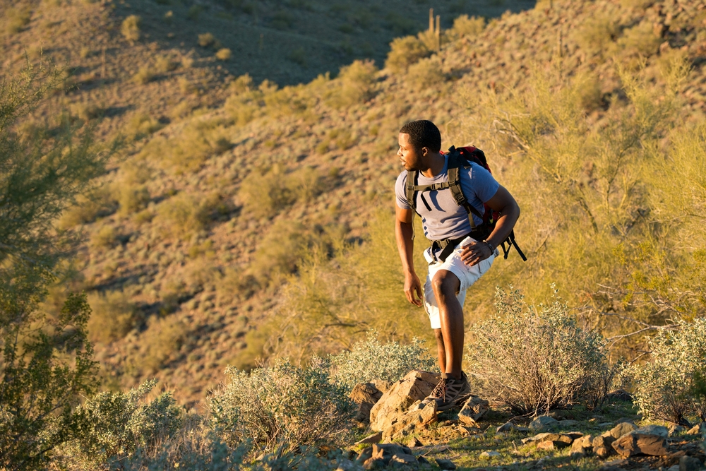 Person hiking through the desert during a sunrise