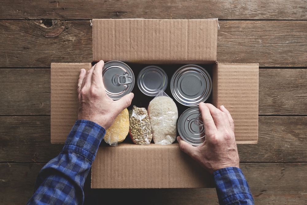 Person putting in dry foods into a cardboard box